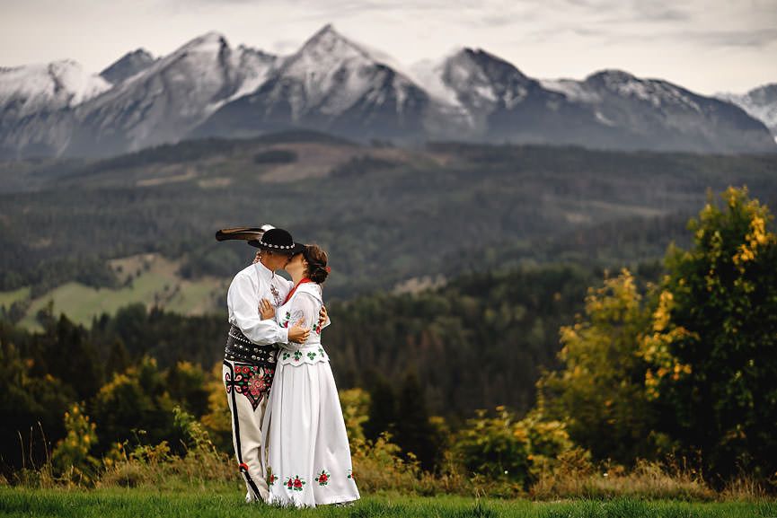 Wesele po góralsku, tradycyjny ślub - zdjęcie pary młodej na tle górskiego krajobrazu w tradycyjnych góralskich strojach - 048