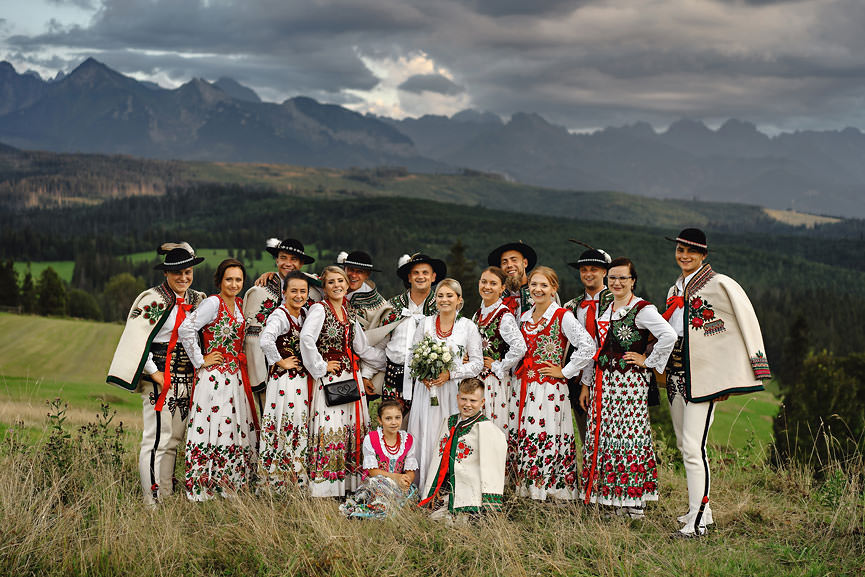 Wesele po góralsku, tradycyjny ślub - zdjęcie pary młodej na tle górskiego krajobrazu w tradycyjnych góralskich strojach - 084